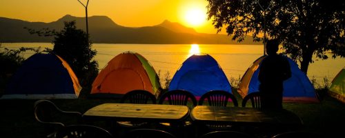 Sunset view at Pawna Lake campsite with colorful tents